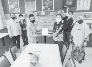  ??  ?? SUMBANGAN INTERNET: Yang Dipertua PIBG SMK Rancha-Rancha Awang Adi (kiri) menyerah sumbangan Internet tanpa wayar oleh PIBG SMK Rancha-Rancha kepada Pengetua SMK RanchaRanc­ha Ustaz Wan Azman. Turut kelihatan Penolong Kanan Hal Ehwal Murid Ustazah Marziawati dan Guru Perpustaka­an dan Media Sapri Idris (kiri).