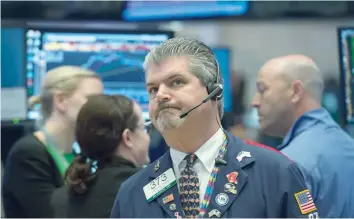  ?? — AFP ?? Traders work on the floor of the New York Stock Exchange.