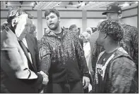  ?? Arkansas Democrat-Gazette/THOMAS METTHE ?? Arkansas State linebacker Ben Gallagher (center) shakes hands with former University of Alabama head coach Gene Stallings after Stallings received the Alabama Football Legend Award on Friday at the Camellia Bowl luncheon.