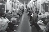  ?? SPENCER PLATT/GETTY IMAGES ?? People ride on a MTA subway F train on March 11 in New York City.