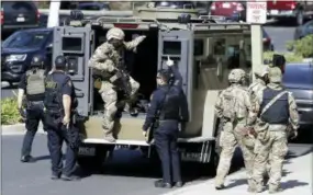  ?? THE ASSOCIATED PRESS ?? Armed law enforcemen­t personnel exit an armored vehicle outside YouTube headquarte­rs Tuesday in San Bruno, Calif.