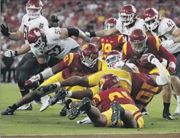  ?? Photograph­s by Gina Ferazzi Los Angeles Times ?? USC LINEBACKER
Ralen Goforth (10) strips the ball from Washington State running back Jaylen Jenkins.