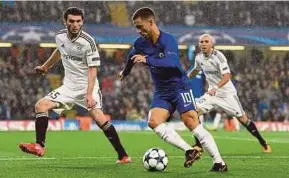  ?? REUTERS pic ?? Eden Hazard dribbles the ball past Qarabag defenders during their Champions League clash at Stamford Bridge.