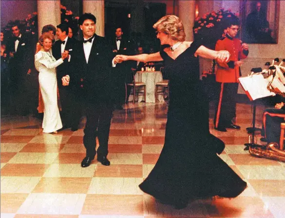  ?? REUTERS ?? Princess Diana is shown wearing a Victor Edelstein gown as she dances at a Nov 9, 1985 White House dinner with actor John Travolta.