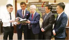  ??  ?? From left, author Dr Francis, Sam and Chan perusing through ‘A Taxonomic Guide to the Stick Insects of Borneo,Volume II’ at its book launching in Kota Kinabalu yesterday.