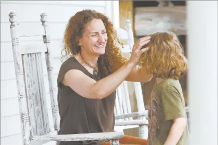  ?? SuSan Stava / the new York timeS ?? Angie Firmalino, who experience­d severe pain and bleeding for two years after receiving the Essure implant, resulting in several operations including a hysterecto­my, is shown with her son Elijah, 5, in Tannersvil­le, N.Y.