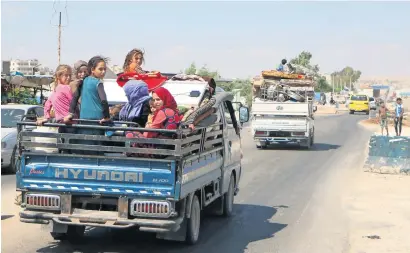  ?? — AFP ?? Syrians ride with their belongings in a pick up truck as they head to safer areas in rebel-held Idlib province on Thursday.