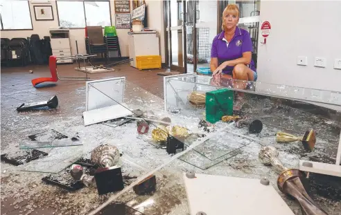  ?? Picture: BRENDAN RADKE ?? SHOCK: Southside Comets secretary Ruth Collins beside glass trophy cabinets smashed in a break-in on Saturday.