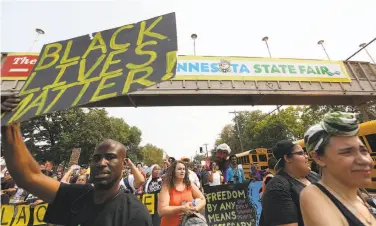  ?? Jim Gehrz / Associated Press ?? People march during a Black Lives Matter protest near the front gate of the Minnesota State Fair, in Falcon Heights. The movement’s fluid, organic nature generates confusion about exactly who is in charge.