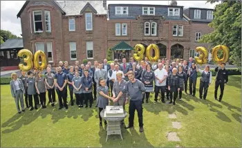  ??  ?? Auchrannie Resort team members join managing director Linda Johnston in cutting a large cake during their 30th birthday celebratio­ns.