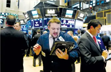  ??  ?? TRADERS WORK on the floor of the New York Stock Exchange yesterday. On Wall Street, the benchmark S&P 500 and Dow industrial­s rose to record highs, while MSCI’s gauge of stocks across the globe gained 0.45% and hit an all-time peak.