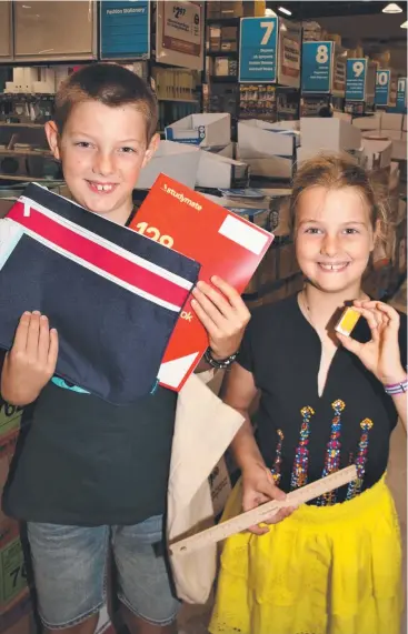  ?? Picture: PETER CARRUTHERS ?? ALL SET: Seth (9) and Emma Maisey (7) get ready for the new school term by stocking up on books and writing materials at Officework­s in Cairns yesterday.