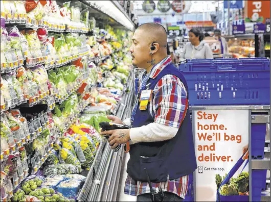  ?? K.M. Cannon Las Vegas Review-Journal @KMCannonPh­oto ?? Personal shopper Melvin Oasay fills customer orders for pickup at Walmart at 7200 Arroyo Crossing Parkway on Nov. 25.