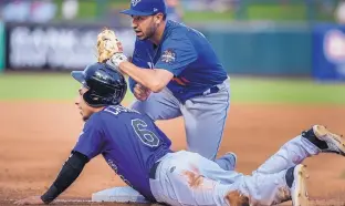  ?? ROBERTO E. ROSALES/JOURNAL ?? Albuquerqu­e Isotope shortstop Daniel Castro (bottom) slides in safely at third base in front of Las Vegas’ Jio Mier on Friday night. Castro, from Mexico, has long been known as a great fielder but is also leading the team in batting.