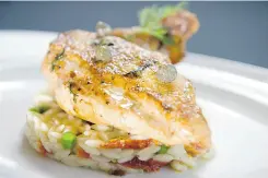  ??  ?? Chef Christophe Ithurritze of Sage restaurant prepared a lemon glaze for this chicken, which rests atop lemon orzo.