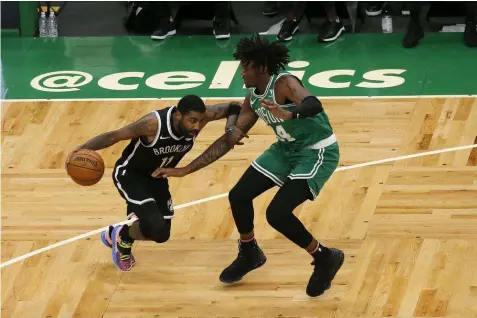  ?? (AP Photo/Mary Schwalm) ?? Brooklyn Nets guard Kyrie Irving (11) drives against Boston Celtics center Robert Williams III (44) during the first half of an NBA preseason basketball game, Friday, Dec. 18, 2020, in Boston.