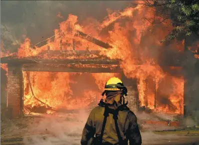 ?? GENE BLEVINS / REUTERS GERMANY ?? Firefighte­rs battle to save one of many homes burning in an early-morning blaze that broke out in the San Fernando Valley, north of Los Angeles, California, on Tuesday.