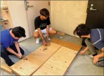  ?? Courtesy photo ?? (Above) From left, Alex Yang, Kyle Fabella and Ansen Chen create the booths for Lucy’s Psychiatry, a student-run peer counseling service in the SCV. (Right) Booths feature Lucy from the Peanuts comic strip.