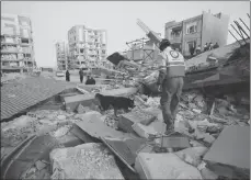  ?? POURIA PAKIZEH/ISNA VIA AP ?? A rescue worker searches debris for survivors with his sniffing dog after an earthquake at the city of Sarpol-e-Zahab in western Iran.