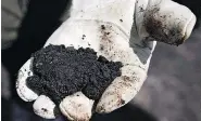  ?? JEFF MCINTOSH / THE CANADIAN PRESS FILES ?? An Alberta oil worker holds raw sand bitumen. Last year, Canada exported $67 billion in oil — most of it to the U.S.