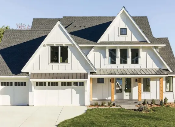  ??  ?? “This modern farmhouse model has the beautiful timeless look of a farmhouse with a white exterior, front porch and cedar posts, yet the modern spin comes with black windows, a standing seam metal roof, and board and batten,” says David.