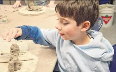  ??  ?? Owen Ellis, 8, works on his clay sculptures during a Kids & Clay workshop at the Cape Breton Centre for Craft and Design on Monday.