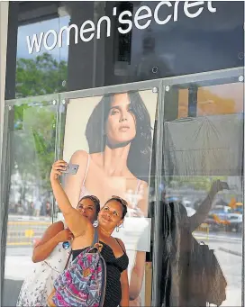  ?? [ AFP ] ?? Teure Aussichten. Kubanerinn­en fotografie­ren sich vor einem der Geschäfte im Gebäude des neuen Luxushotel­s Manzana Kempinski in Havanna.
