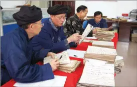  ?? ?? Shuishu master Yang Shengzhao (second from left) discusses the written language with others.