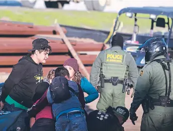  ??  ?? PATRULLA. Migrantes centroamer­icanos que viajan en una caravana son detenidos por agentes.