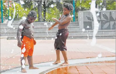  ?? Andrea Smith The Associated Press ?? Kai Frazier and Chance Seawright, brothers visiting from Aiken, South Carolina, cool off Monday in the Fountain of Rings in Centennial Olympic Park in Atlanta. A heat wave that has hit 13 states in the South and Midwest is projected to last for days.