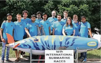  ?? FOTO: NN ?? William Megill (Mitte) mit seinem internatio­nalen Hochschule-Team und dem „Hai“.