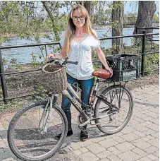  ?? VIP PETERBOROU­GH ?? Hailey Finlay poses next to her bicycle, which is the method of transport of choice for her business, Very Important Pet (VIP) Peterborou­gh. Finlay recommends ensuring that you know where the amenities are when choosing your bike route to go to work.
