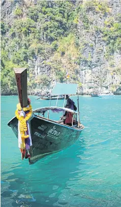  ?? ?? A long-tail boat waiting for tourists at Pileh Lagoon. Phi Phi locals make a living captaining boats for visitors. During the pandemic, some of them had to resort to fishing instead.