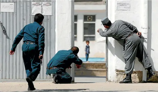  ?? PHOTOS: REUTERS ?? Afghan policemen try to rescue four-year-old Ali Ahmad at the site of a suicide attack followed by a clash between security forces and insurgents in Kabul.