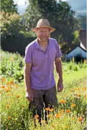  ??  ?? Botanist Paul Richards, knee deep in glowing calendula at his herb farm in Herefordsh­ire.