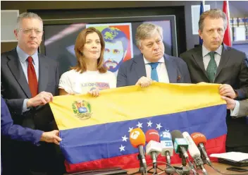  ?? — Reuters ?? Leopoldo Lopez (2nd R), father of Venezuela’s jailed opposition leader Leopoldo Lopez, and his daughter Diana Lopez (2nd L) hold up a Venezuelan flag next to lawyer Javier Cremades (R) and former Spanish justice minister Alberto Ruiz Gallardon during a...