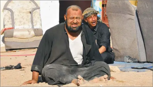  ??  ?? Iraqi residents grieve at the site of a bomb attack in Nassiriya, 300 km southeast of Baghdad on Thursday. A suicide bomber targeting Shiite pilgrims killed at least 73 people.