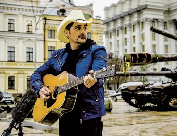  ?? EFREM LUKATSKY AP ?? Country music singer Brad Paisley performs near damaged Russian tanks in central Kyiv, Ukraine, on April 12.