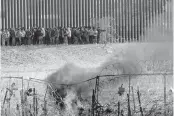  ?? OMAR ORNELAS USA TODAY NETWORK ?? Hundreds migrants line up on the border wall after they breached barriers set up by the Texas National Guard on the Rio Grande in El Paso, Texas, earlier this month. The migrants were hoping to be processed by Border Patrol.