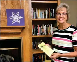  ?? PILOT PHOTO / JAMIE FLEURY ?? Marshall County Council on Aging Event and Activity Planner Tina Morales is eager to launch People’s University of Marshall County Fall Semester 2019. Morales is standing by the free books available to the public located on the shelves by the fireplace. On the mantle is a paper snowflake designed by Monty Peden who will be teaching ‘Scissor Snips’ again this year.