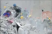  ?? AP ?? Rescue workers search for survivors in the rubble of an apartment building that collapsed in Mexico City.