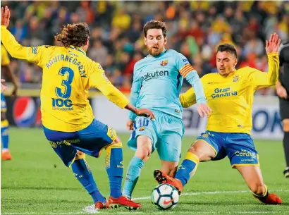  ?? AP ?? Lionel Messi (centre) duels against Las Palmas’ Matias Aguirregar­ay and Ximo Navarro during a La liga match. —