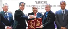  ??  ?? Marconi (second left) exchanges the signed MoU with Amirul, witnessed by Kamarulnaj­uib (centre) and others.