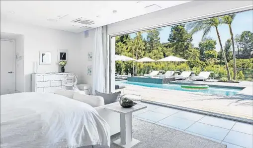  ?? Rodeo Realty ?? GLASS WALLS IN filmmaker Ron Curtis’ Beverly Hills home facilitate indoor-outdoor living. The house is listed at $12.995 million.