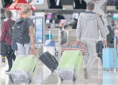  ?? APICHIT JINAKUL ?? Travellers haul luggage at Suvarnabhu­mi airport in Samut Prakan.