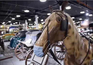  ?? PHOTOS BY BEN HASTY — MEDIANEWS GROUP ?? A COVID-complying masked plastic horse is part of a display at the Boyertown Museum of Historic Vehicles earlier this year. The museum in the former home of the Boyertown Auto Body Works has reopened to guests. Many similar places have not, but they want to.