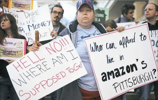  ?? Steve Mellon/Post-Gazette ?? Linda Warnan of Duquesne was one of about 35 people who gathered on Thursday in the shadow of the David L. Lawrence Convention Center, Downtown, to discuss the impact Amazon’s HQ2 would have on housing in Pittsburgh. Visit post-gazette.com for a video...