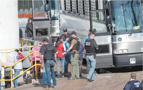  ??  ?? Empleadas de una planta de procesamie­nto de alimentos son escoltadas por agentes migratorio­s, en Morton, Mississipp­i.