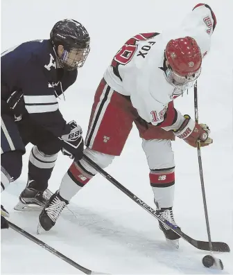  ?? HERALD PHOTO BY JIM MICHAUD ?? STICK TO IT: Yale’s Ted Hart, left, and Harvard’s Adam Fox vie for the puck during the first period last night at the Bright-Landry Hockey Center in Allston.