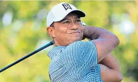  ??  ?? Tiger Woods carefully watches his drive during a practice round.